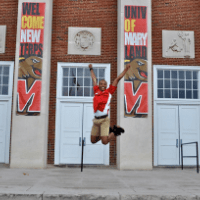 student jumping in air at STAMP building