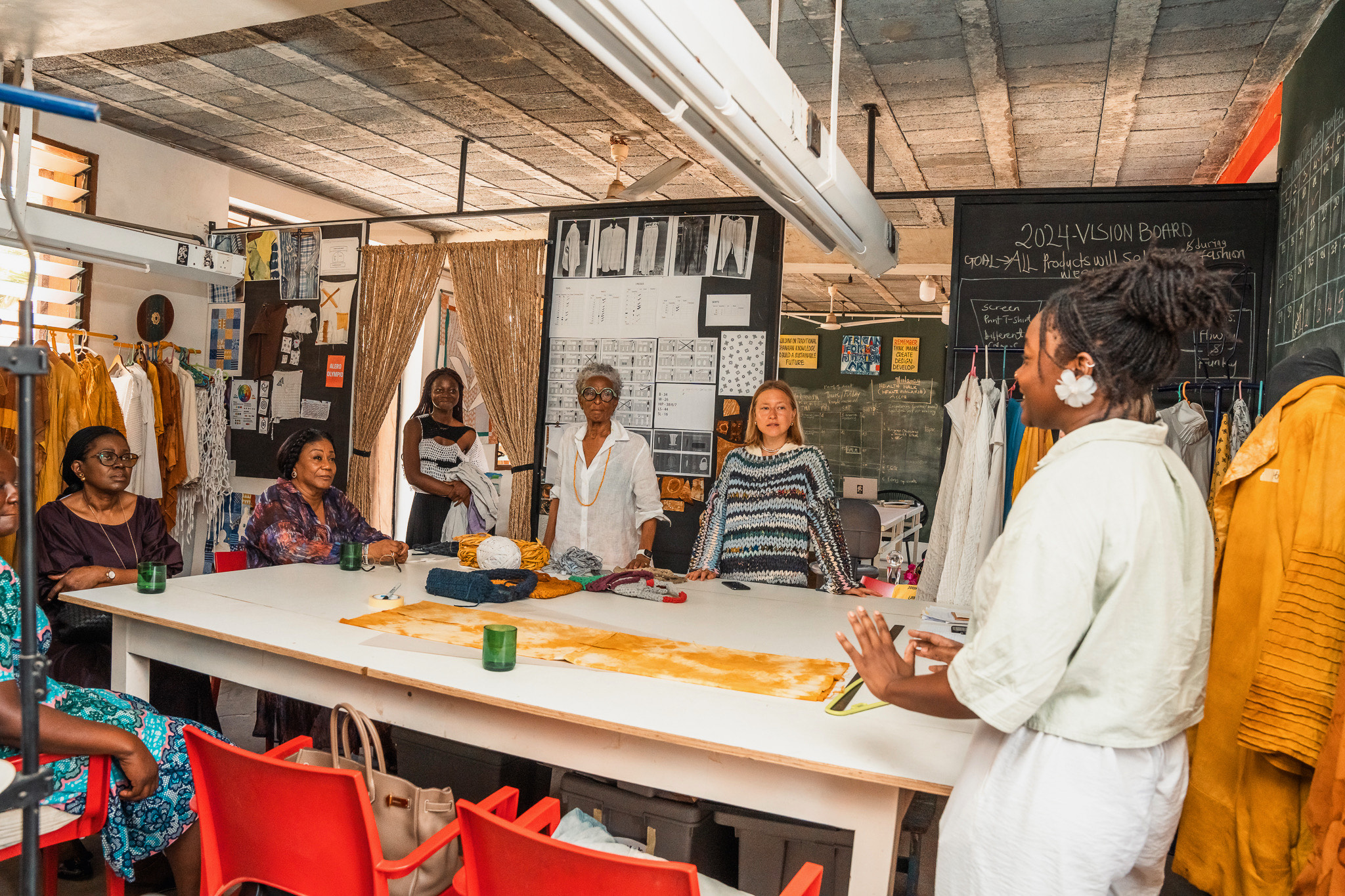 group of women talking at table with clothing and fashion designs on walls